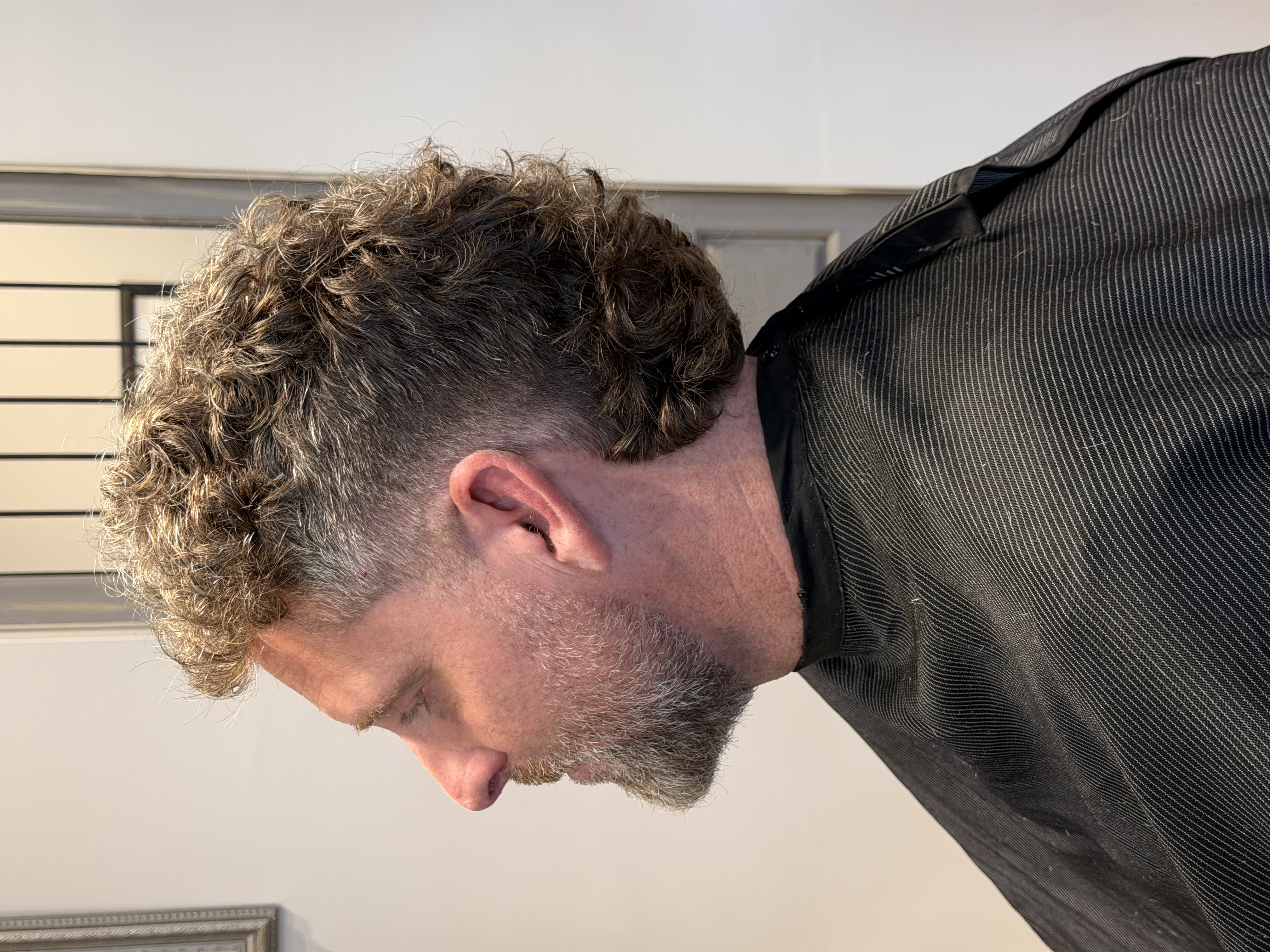 Textured curly mullet with burst fade finished at Maxx's Shaving Room in Stuart Florida